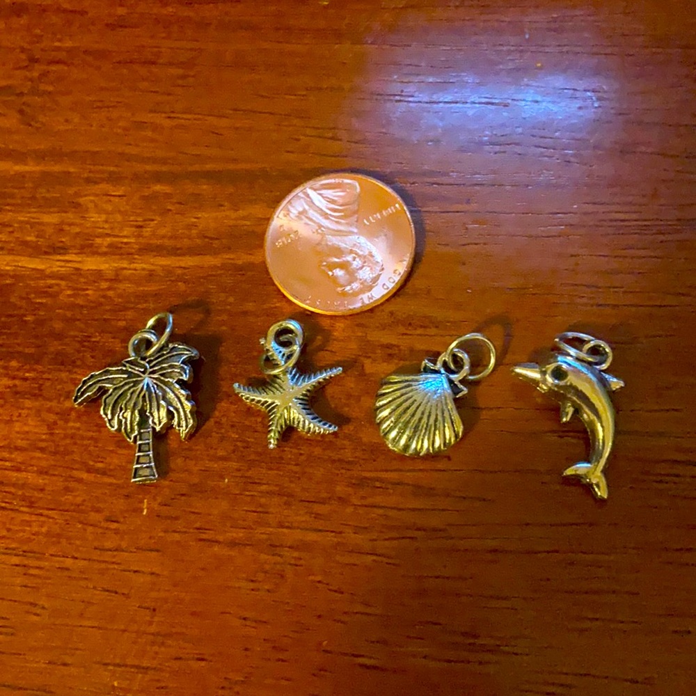 4 Tropical silver toned charms, dolphin, palm tree, starfish & shell.